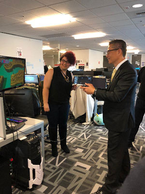 The Financial Secretary, Mr Paul Chan (right) in Seattle plays a video game created by students of the DigiPen Institute of Technology during his visit there.